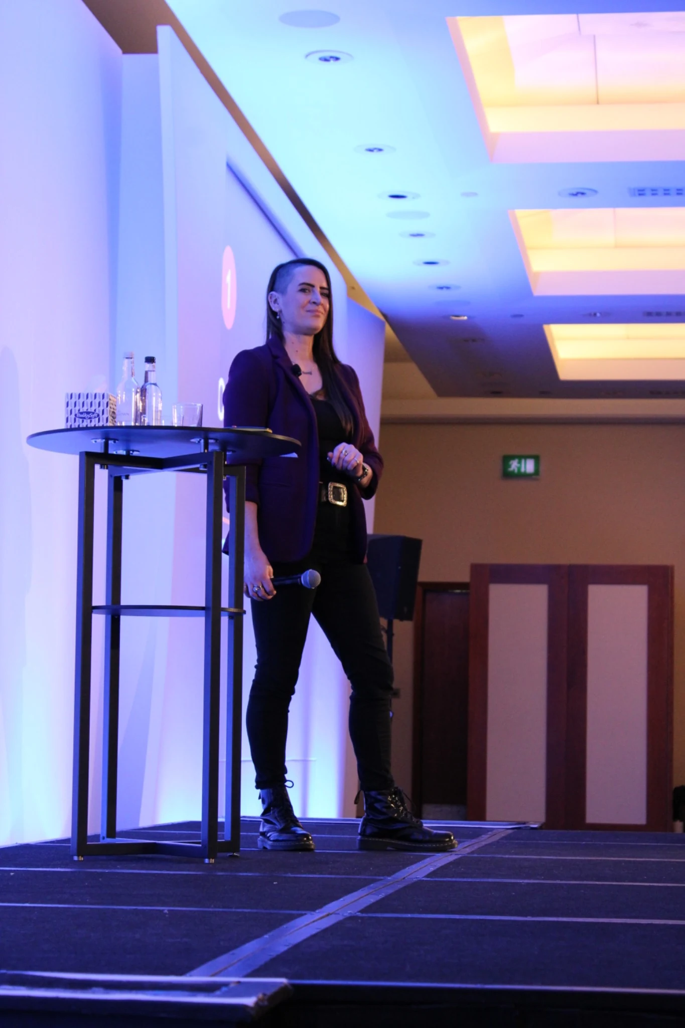 Claire speaking on stage at an event, photographed full length